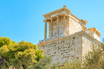 A large building with a white roof and a green tree in front of it, the Acropolis of Athens