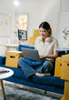 © PaeGAG - Young entrepreneur managing her online business and preparing orders for shipment. She is sitting comfortably on the couch in her new apartment