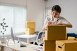 © PaeGAG - Young entrepreneur carefully prepares packages in her home office for shipment, showcasing dedication to her online business