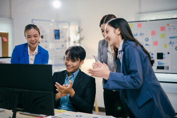 Poster - Diverse asian team celebrates success in office, happy and excited, focusing on computer screen with data for project. Bright modern setting shows achievement in corporate world