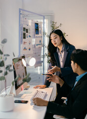 Fototapete - Two business professionals are collaborating on a project, analyzing data displayed on a computer screen in a modern office setting