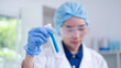 © Supapich - Professional expertise woman research scientist compare blue liquid in test tube or glassware beaker in chemical scientific experiment laboratory, female doctor pharmacy biology medicine person