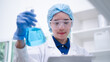 © Supapich - Woman scientist chemist holding laboratory blue liquid beaker test tube equipment for discovery analysis science chemical medicine development experiment technology biotechnology development