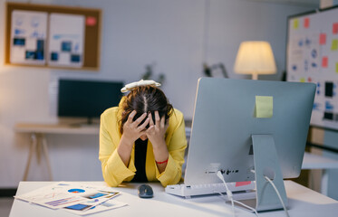 Stressed businesswoman at desk in office, overwhelmed from computer work. Tired, headache, burnout, frustrated, sad, anxious. Workplace stress affects mental health