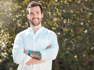 Portrait, arms crossed and happy man in nature for vacation, travel and pride at park. Face, smile and confident person outdoor for adventure, tourism and relax in countryside on trip in Australia