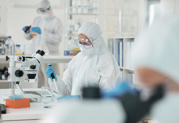 Wall Mural - People, ppe and scientist checking virus, test results or pharmaceutical innovation with mask. Safety, gear or lab technician team at desk for bacteria research, medical danger or vaccine development