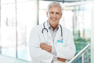 Wall Mural - Portrait, man and doctor with confident in hospital for medical service, diagnosis advice and career pride. Mature, surgeon and arms crossed with healthcare trust, about us and treatment of wellness