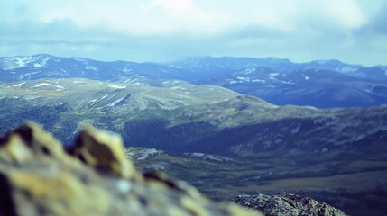 Sticker - Stunning Mountain Landscape: Expansive View of Rolling Hills and Clouds with Rocky Foreground - Ideal for Nature Themes