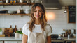© Alina Tymofieieva - A smiling young woman in a striped apron stands in a bright kitchen surrounded by fresh ingredients and decorative kitchenware
