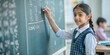 © Htet Wai Phyo - intelligent indian elementary school kid solving maths problem on chalkboard at classroom -concept of talented, brilliant student and education.