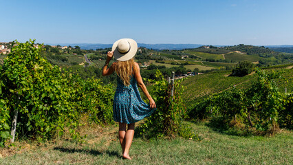 Wall Mural - Woman with dress and hat in vineyard in Tuscany, Italy