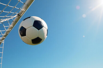 Soccer Ball Flying into Goal Net Against Blue Sky