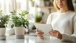 © Thanyaporn - A woman is sitting at a table with a tablet in her hand