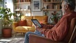 © peerawat - A visually impaired person using a touchscreen tablet with voice feedback features, sitting in a comfortable living room with ergonomic furniture designed for accessibility.