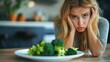 © Meow Creations - Picky eater, Young woman looking unhappy at plate full of broccoli, expressing disgust for healthy food.