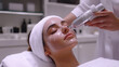 © Meow Creations - Woman receiving hydradermabrasion facial treatment in beauty salon. Cosmetologist using hydra peel machine on client's face. Concept of skincare, hydration, anti aging, rejuvenation, and beauty