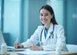 © Thierry - Happy healthcare worker sitting at her desk in a clinic.