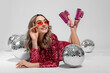 © New Africa - Beautiful woman in sunglasses and sequin dress among disco balls on white background