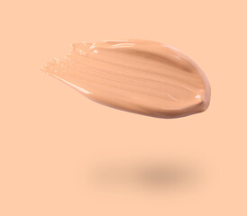 Poster - Skin foundation in air on peach color background. Cosmetic product