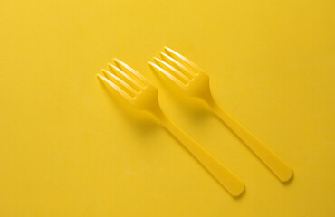 Set of plastic forks on yellow background