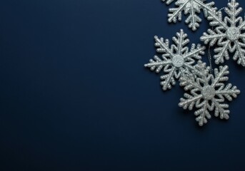 Wall Mural - silver glittering snowflakes hanging on navy blue background creating winter holidays greeting card