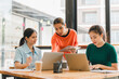 © PRIME STOCK LAB - Collaborative meeting with three women discussing ideas while working on laptops. atmosphere is focused and productive, showcasing teamwork and creativity in modern workspace