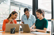 © PRIME STOCK LAB - Collaborative women working together in modern office space, engaged in productive discussion while using laptops. Their expressions reflect focus and teamwork