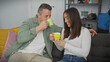 © Krakenimages.com - A smiling couple enjoying coffee together on a cozy sofa in a modern living room setting