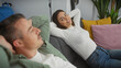 © Krakenimages.com - A woman and a man relaxing in a cozy living room with colorful pillows and modern decor