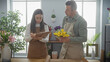 © Krakenimages.com - A man and woman, florists, working together indoors at a flower shop, arranging bouquets with focus and coordination.