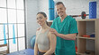 © Krakenimages.com - A female patient and male physiotherapist smiling together in an indoor physiotherapy clinic.