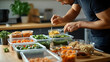© Prasanth - A lifestyle shot of a man enjoying a homemade meal prep with containers filled with nutritious and portioned meals. Generative AI