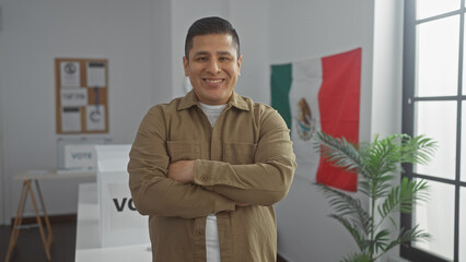 Handsome hispanic man smiling confidently in an election room indoor with a mexican flag