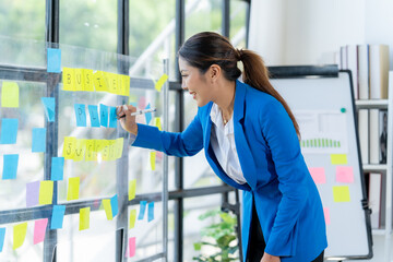 Strategic Planning Session: A focused businesswoman in a blue blazer actively participates in a brainstorming session.