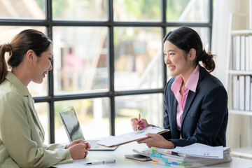 Businesswomen Collaborating: Two professional women engage in a productive meeting, showcasing their collaborative spirit and shared focus.