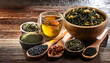 © Konstantin Sigaev - A variety of loose leaf teas and herbal infusions in wooden bowls and spoons, accompanied by a glass of steeped tea. Perfect for tea enthusiasts and natural wellness concepts.