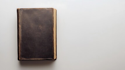 Top view of a closed book with a leather cover on a white background