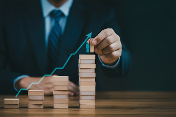 The businessman and the concept of growth. Wooden cubes with arrow graphic rising above a wooden table, Business concept.