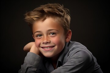 Portrait of a cute little boy on a dark background. Studio shot.