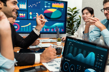 Diverse group of business analyst team analyzing financial data report. Finance data analysis chart and graph dashboard show on TV screen in meeting room for strategic marketing planning. Habiliment