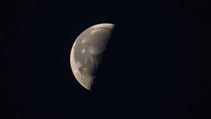 A detailed depiction of the moons rugged surface illuminated by stars against a night sky