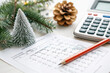 © Dudarte - Uma caneta e uma calculadora sobre uma mesa, cercadas por elementos natalinos, sugerem a organização financeira para as festividades.