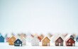 © annebel146 - Colorful miniature houses arranged in a row isolated on white background. Urban city background banner. Copy space