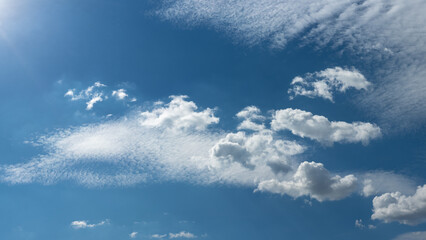Wall Mural - spring or summer blue sky with light fluffy clouds. nice serene weather. peaceful cloudscape in 16x9 format