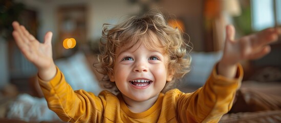 Wall Mural - Happy little boy with blonde curly hair laughing and reaching out his arms.