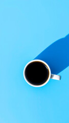 Canvas Print - white mug filled with black coffee on blue background