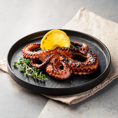 grilled octopus with lemon slice and oregano