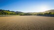 © aubriella - A serene outdoor horse riding arena with neatly maintained sand footing and a backdrop of rolling hills, surrounded by a clear blue sky and early morning light, Minimalist style