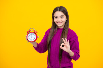 Poster - Teen student girl with clock isolated on yellow background. Child back to school. Education and time concept.