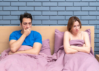 Frustrated and depressed man sitting in the bed after conflict with his wife because of his erectile dysfunction problem